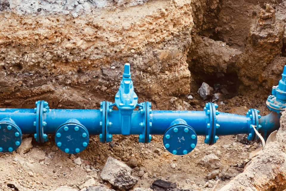 a blue pipe laying on top of a pile of dirt