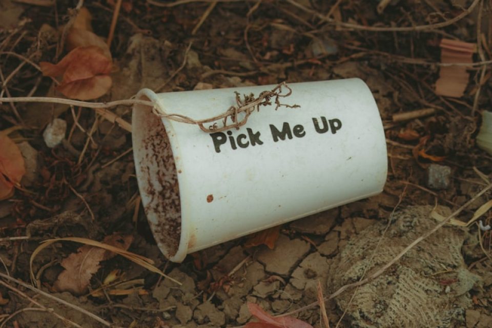 a white cup that says pick me up on the ground
