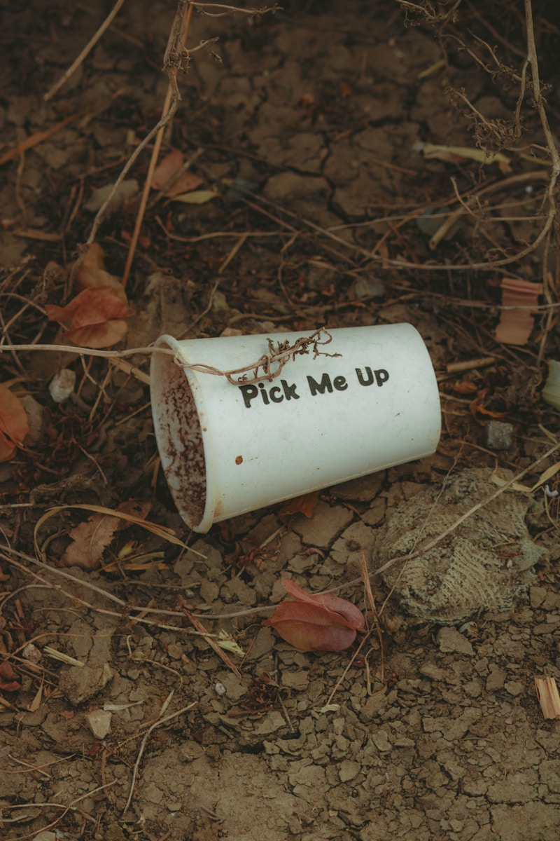 a white cup that says pick me up on the ground
